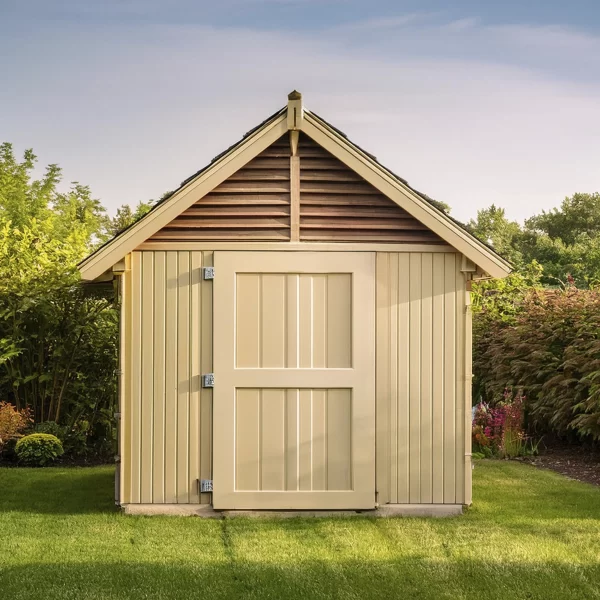 Cobertizo de almacenamiento con puertas ubicado en un jardín en formato cuadrado